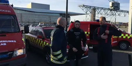 Tre dykkere ved rød Beredskabsbil